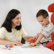 Child with cerebral palsy painting, mental physical disorders sensory therapy